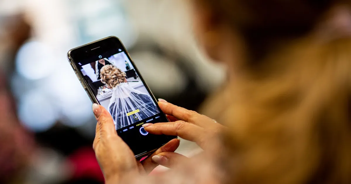 Femme photographiant une coiffure de mariée avec son smartphone