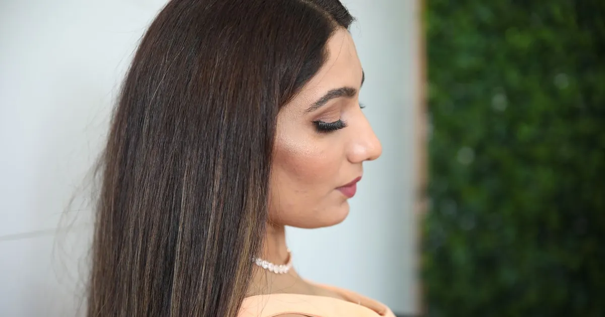 Portrait de profil d'une femme élégante aux longs cheveux et collier de perles.