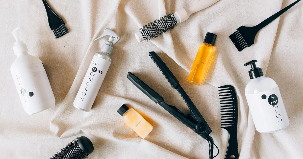 Vue de dessus de produits et outils capillaires sur un tissu texturé.