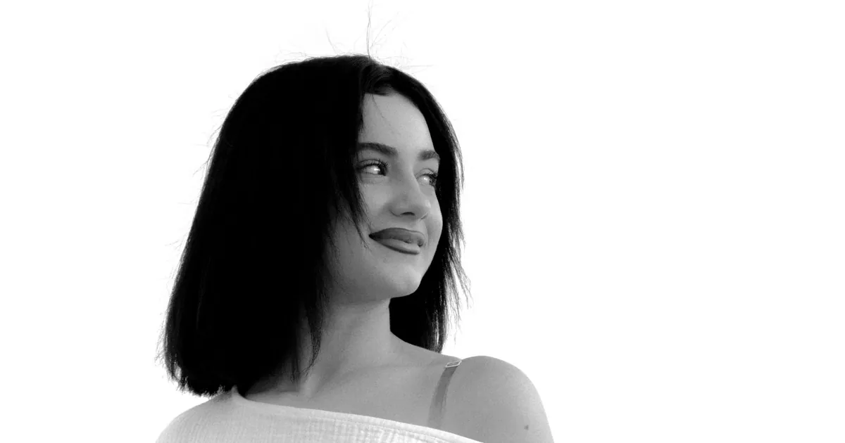 Portrait noir et blanc d'une femme élégante au regard détourné, ambiance sereine.