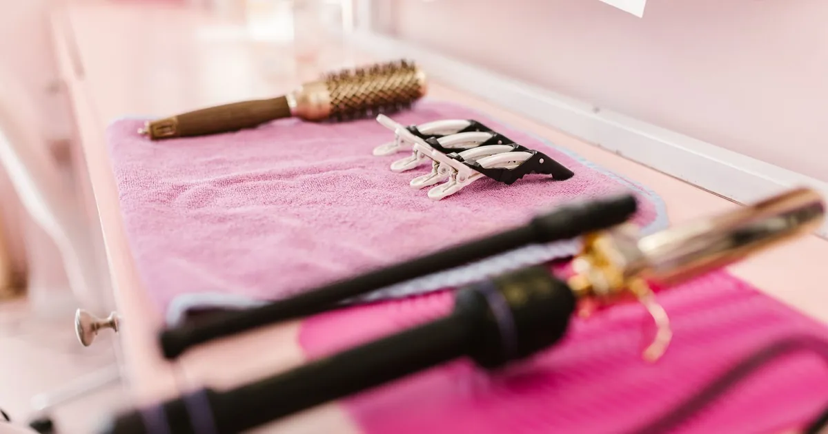 Outils de coiffure disposés sur une serviette rose en salon