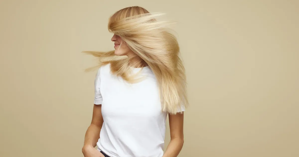 Femme blonde élégante en mouvement, mettant en valeur ses cheveux à Copenhague.