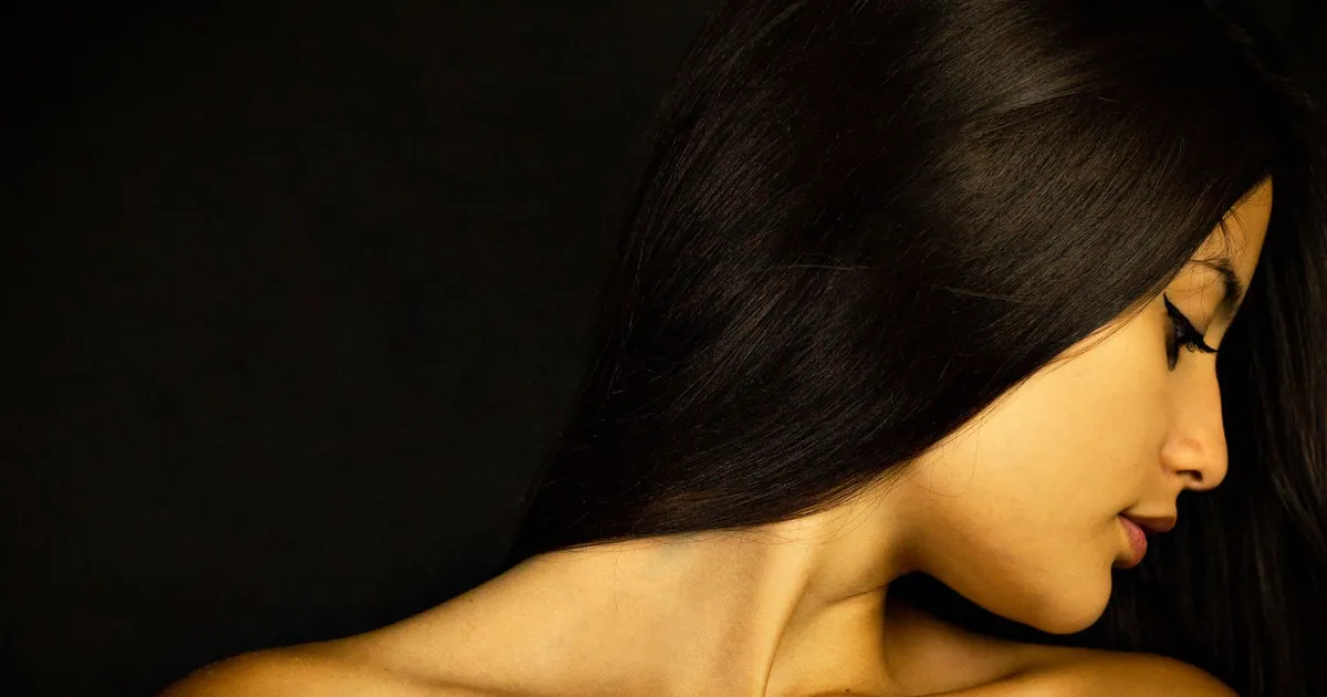 Portrait serein d'une femme aux longs cheveux sombres, profil gracieux.