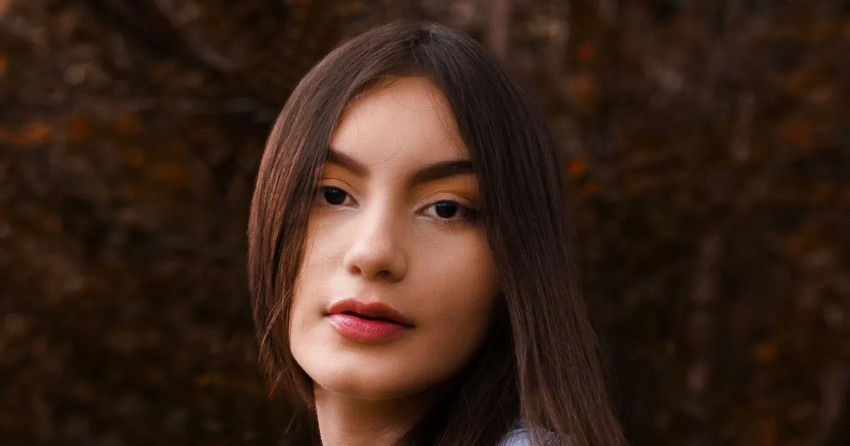 Portrait rapproché d'une jeune femme aux longs cheveux en automne