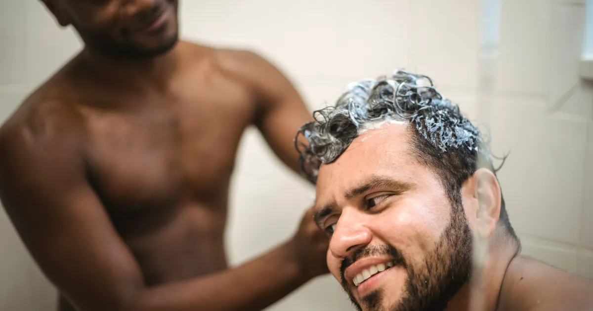 Couple se lavant les cheveux sous la douche dans un moment de tendresse
