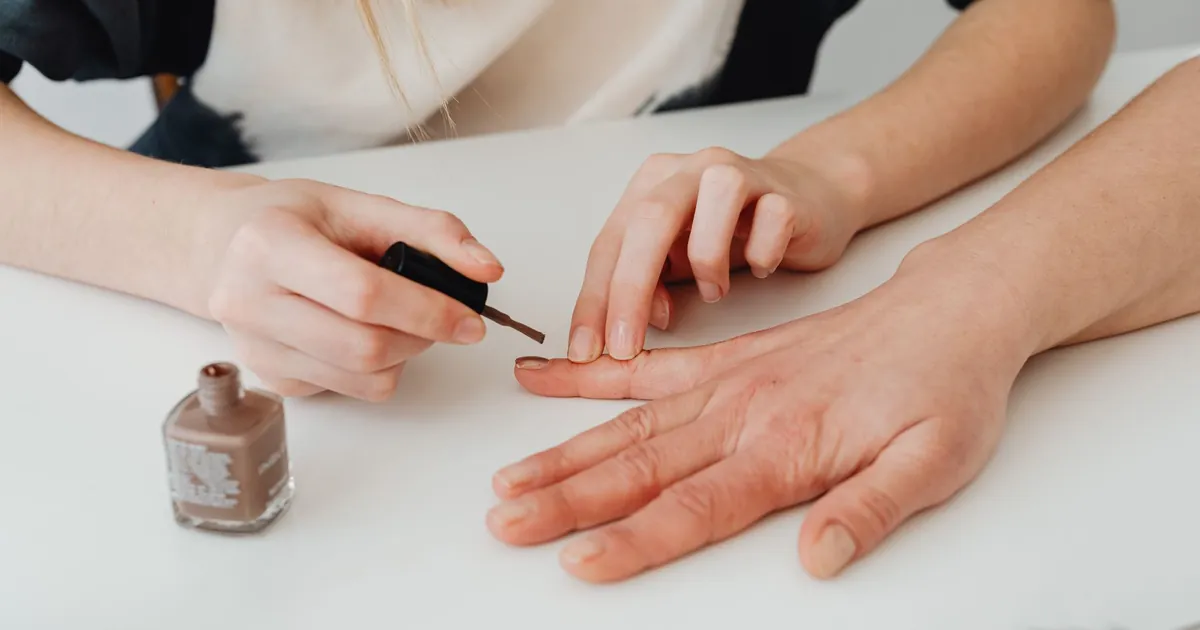 Mains en manucure, pose de vernis en salon
